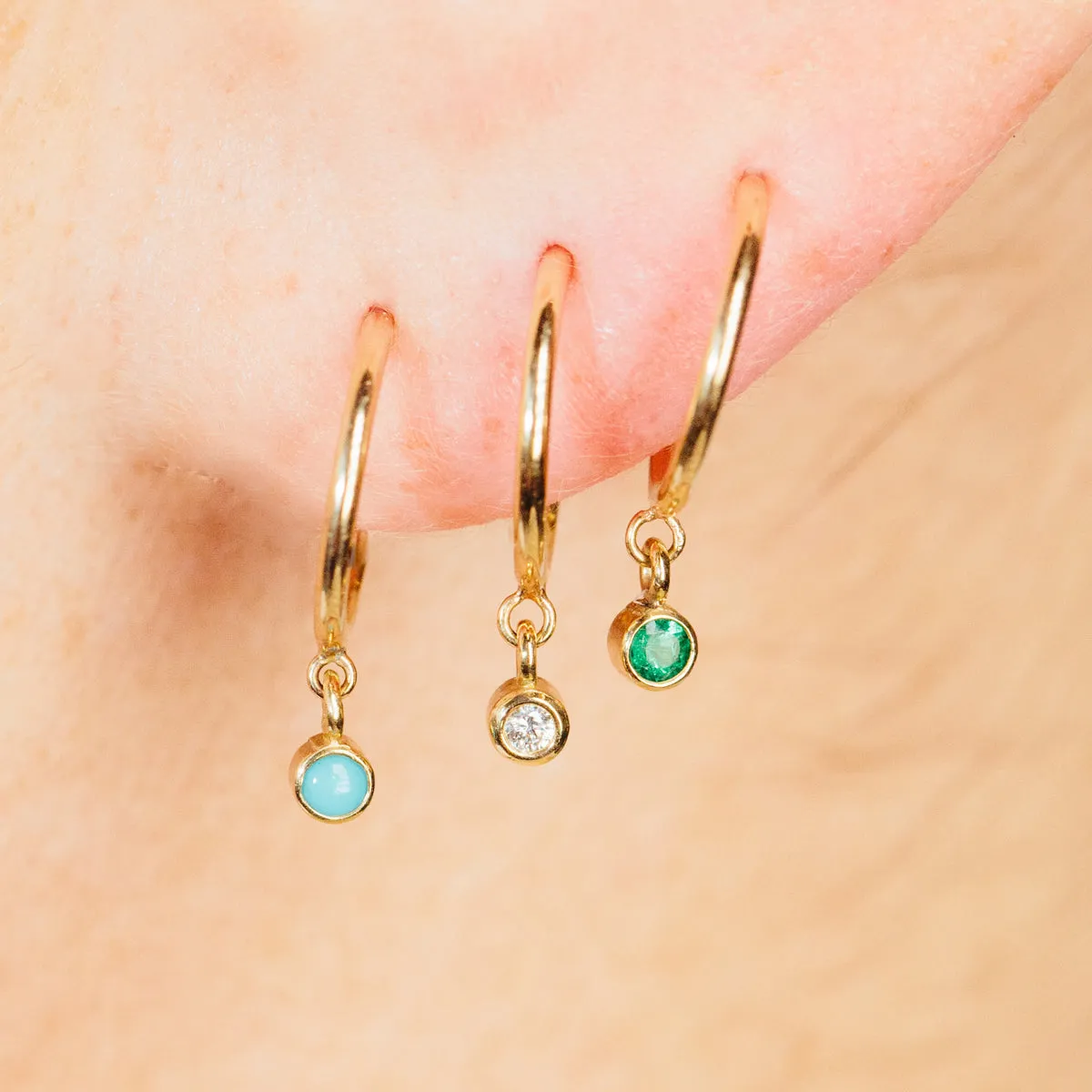 14k Dangling Emerald Huggie Hoops | May Birthstone